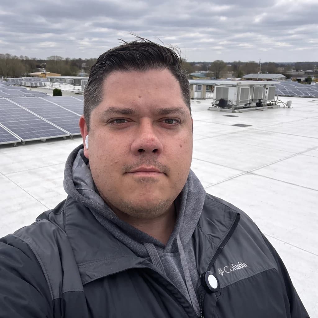 Joe Lesher on a commercial rooftop with solar panels